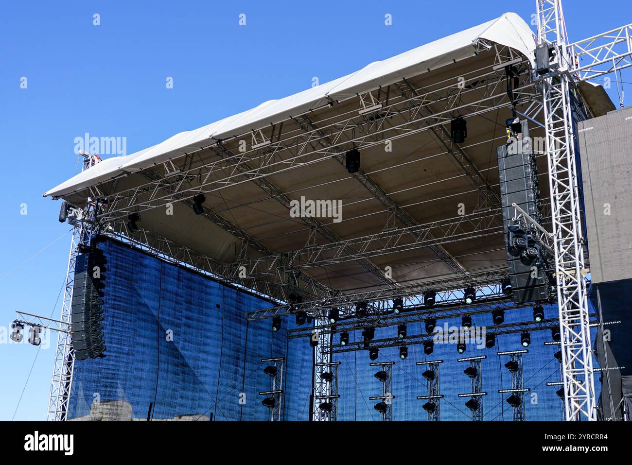 Frammento di capriate in alluminio, elementi di illuminazione e impianto audio di un grande palcoscenico da concerto all'aperto Foto Stock