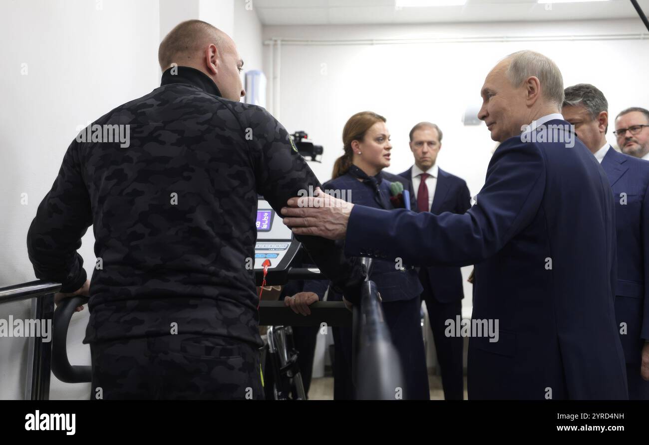 Mosca, Russia. 3 dicembre 2024. Il presidente russo Vladimir Putin, giusto, con un soldato durante l'addestramento su una gamba protesica presso il Priorov National Medical Research Center of Traumatology and Orthopaedics in occasione della giornata internazionale delle persone con disabilità, 3 dicembre 2024 a Mosca, Russia. Il centro sta fornendo riabilitazione e protesi per i soldati feriti nell'invasione Ucraina. Crediti: Gavriil Grigorov/piscina del Cremlino/Alamy Live News Foto Stock