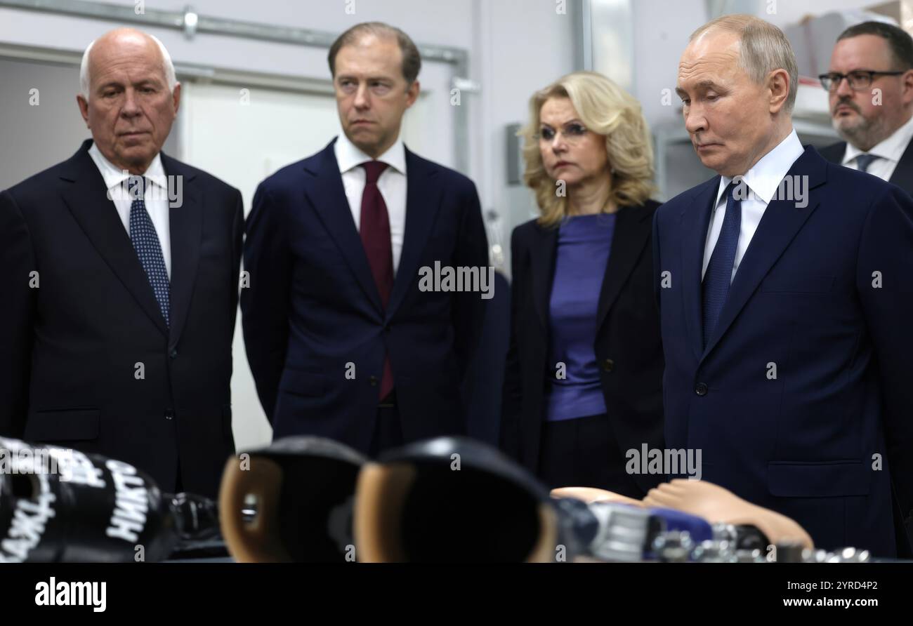 Mosca, Russia. 3 dicembre 2024. Il presidente russo Vladimir Putin, a destra, vede il processo di creazione di una gamba protesica presso il Priorov National Medical Research Center of Traumatology and Orthopaedics in occasione della giornata internazionale delle persone con disabilità, 3 dicembre 2024 a Mosca, Russia. In piedi da sinistra: Rostec DG Sergei Chemezov, primo vice primo ministro Denis Manturov, vice primo ministro Tatyana Golikova, presidente Vladimir Putin e ministro del lavoro e della protezione sociale Anton Kotyakov. Crediti: Gavriil Grigorov/piscina del Cremlino/Alamy Live News Foto Stock