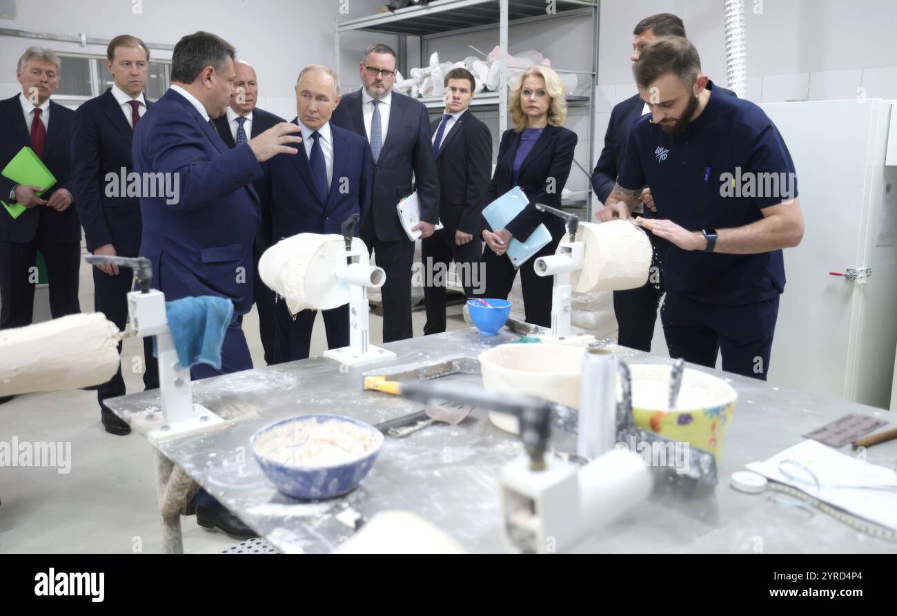 Mosca, Russia. 3 dicembre 2024. Il presidente russo Vladimir Putin, centro, vede una gamba protesica fatta durante una visita al Priorov National Medical Research Center of Traumatology and Orthopaedics in occasione della giornata internazionale delle persone con disabilità, 3 dicembre 2024 a Mosca, Russia. Il centro sta fornendo riabilitazione e protesi per i soldati feriti nell'invasione Ucraina. Crediti: Gavriil Grigorov/piscina del Cremlino/Alamy Live News Foto Stock