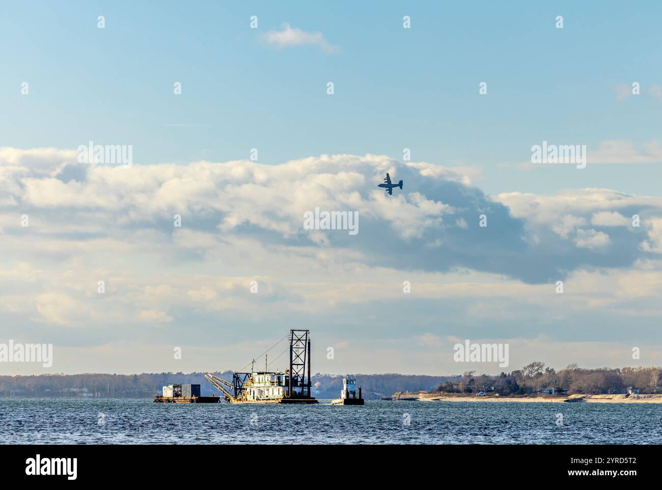 un aereo militare basso che vola sopra un rimorchiatore e sbarca al riparo di shelter island, new york Foto Stock