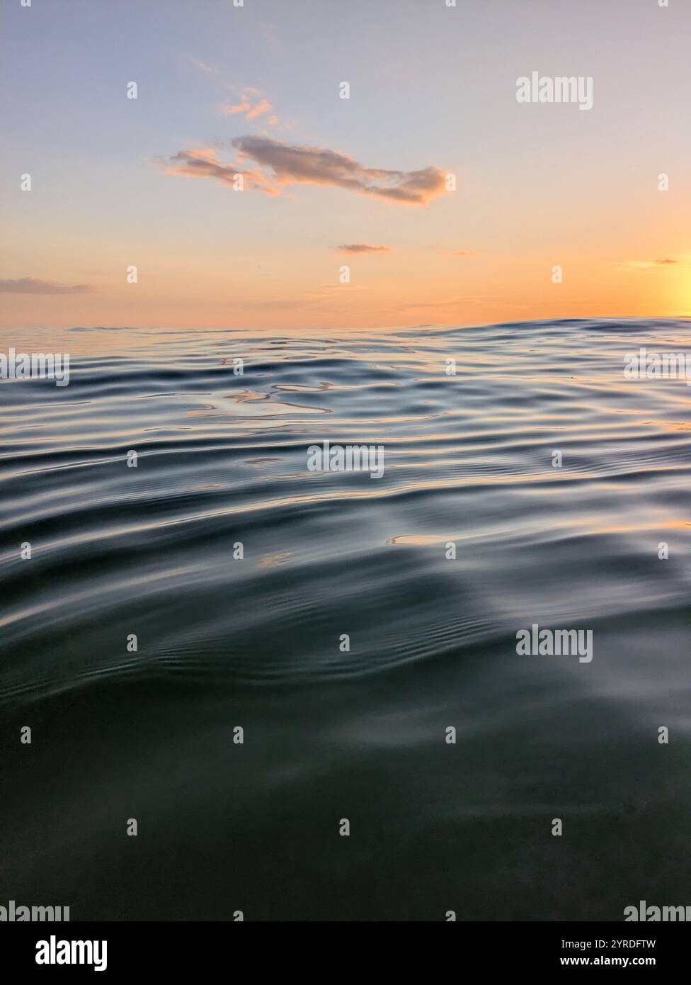 Onde fluide e nuvole al tramonto Foto Stock