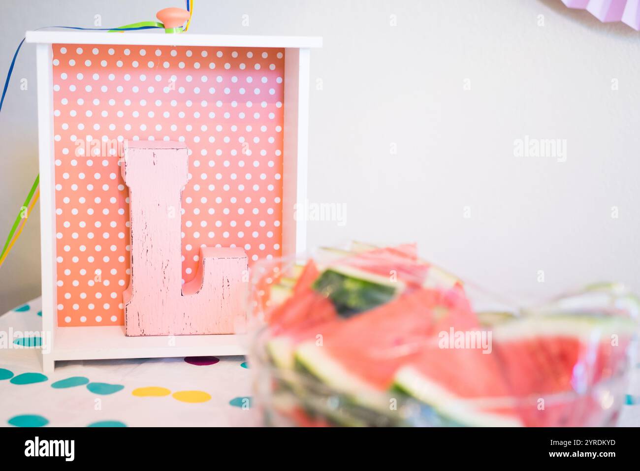 Decorazioni a pois rosa con fette di anguria e lettera L in legno - vibrazioni estive per feste Foto Stock
