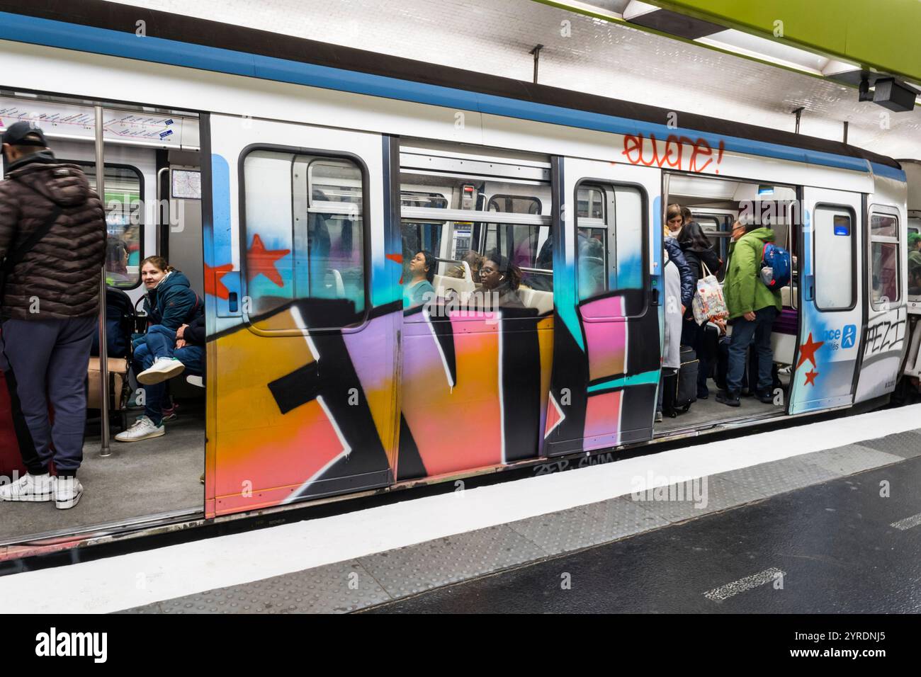 Passeggeri sulla metropolitana di Parigi, in treno coperti di graffiti. Foto Stock