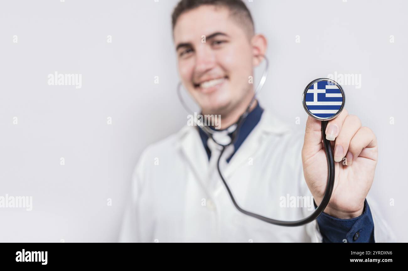 Medico sorridente mostrando stetoscopio con bandiera della Grecia. Concetto sanitario nazionale della Grecia Foto Stock