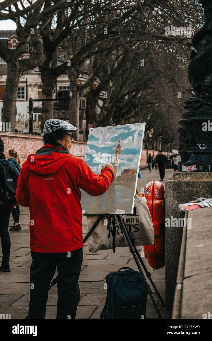 Un uomo che dipinge il Big Ben a Londra, catturando l'iconica torre dell'orologio tra lo skyline storico della città e l'atmosfera vivace. Foto Stock