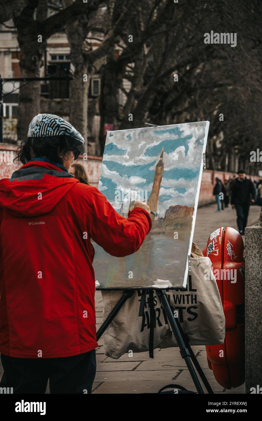 Un uomo che dipinge il Big Ben a Londra, catturando l'iconica torre dell'orologio tra lo skyline storico della città e l'atmosfera vivace. Foto Stock