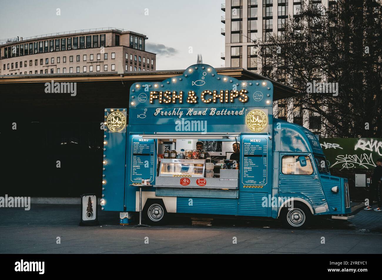 Un popolare furgone di fish and chips a Londra che serve deliziosi piatti tradizionali britannici di strada, catturando l'essenza della cucina locale e il vivace cit Foto Stock