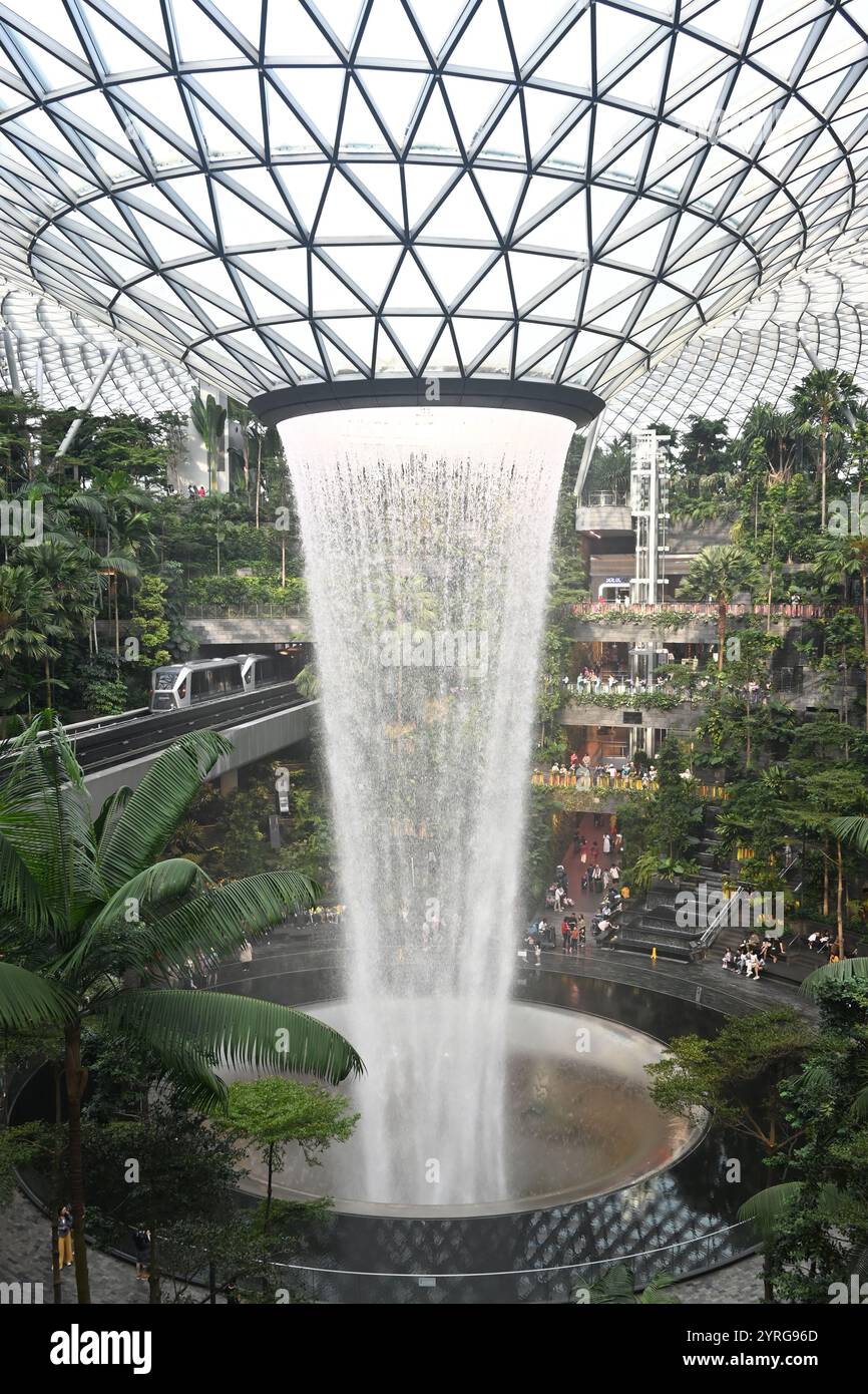 Cascata interna nel lussureggiante Giardino tropicale con lucernario all'Aeroporto Changi di Singapore Foto Stock