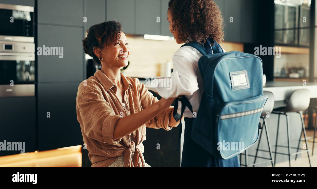 Mamma, ragazza e felice con l'uniforme scolastica in casa per prepararsi o prepararsi per l'istruzione elementare. Appartamento, persone e genitori con bambino per il primo giorno Foto Stock