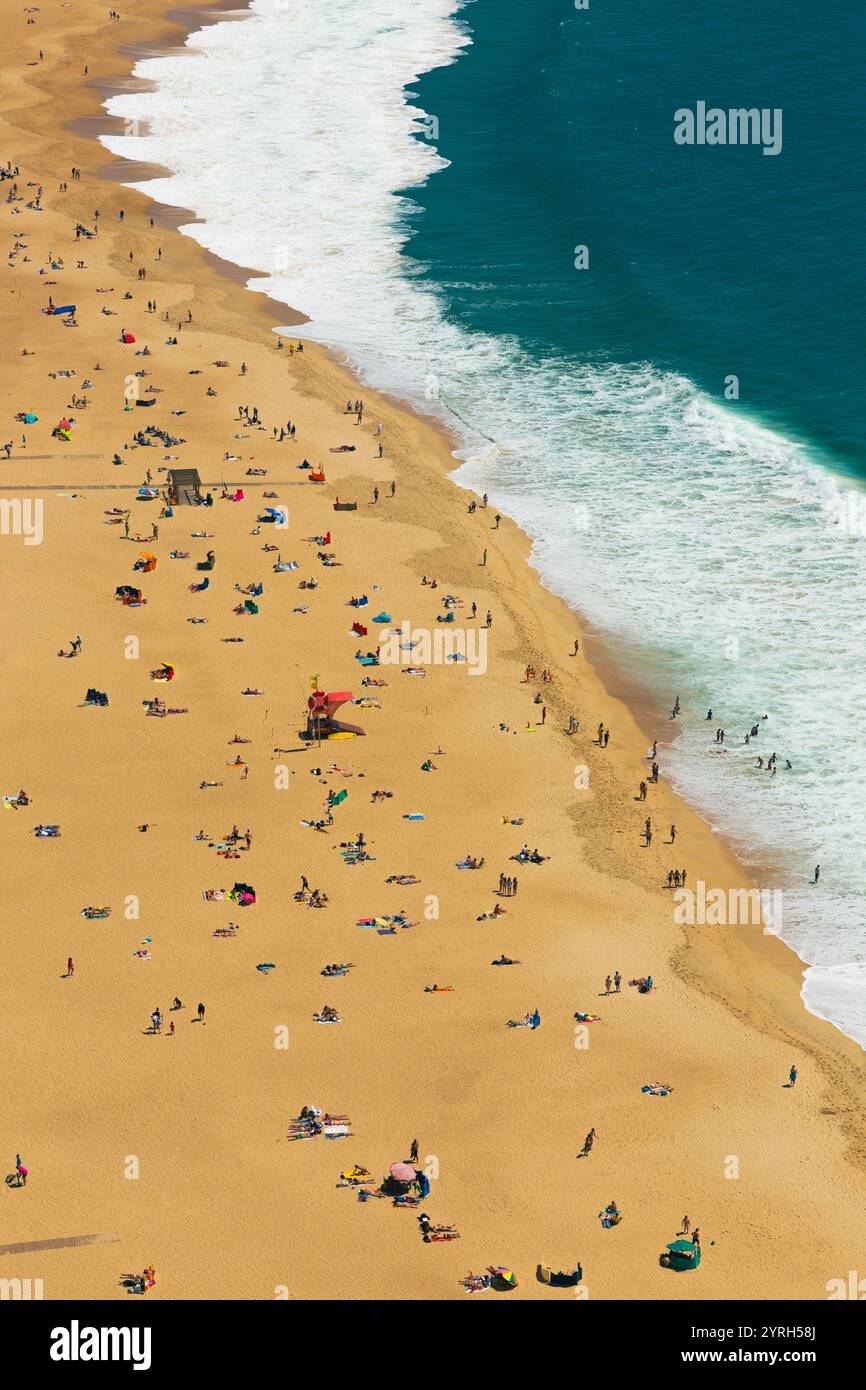 Vista aerea della spiaggia di praia de nazare che mostra ai turisti il relax e il mare durante una splendida giornata estiva a nazare, in portogallo Foto Stock