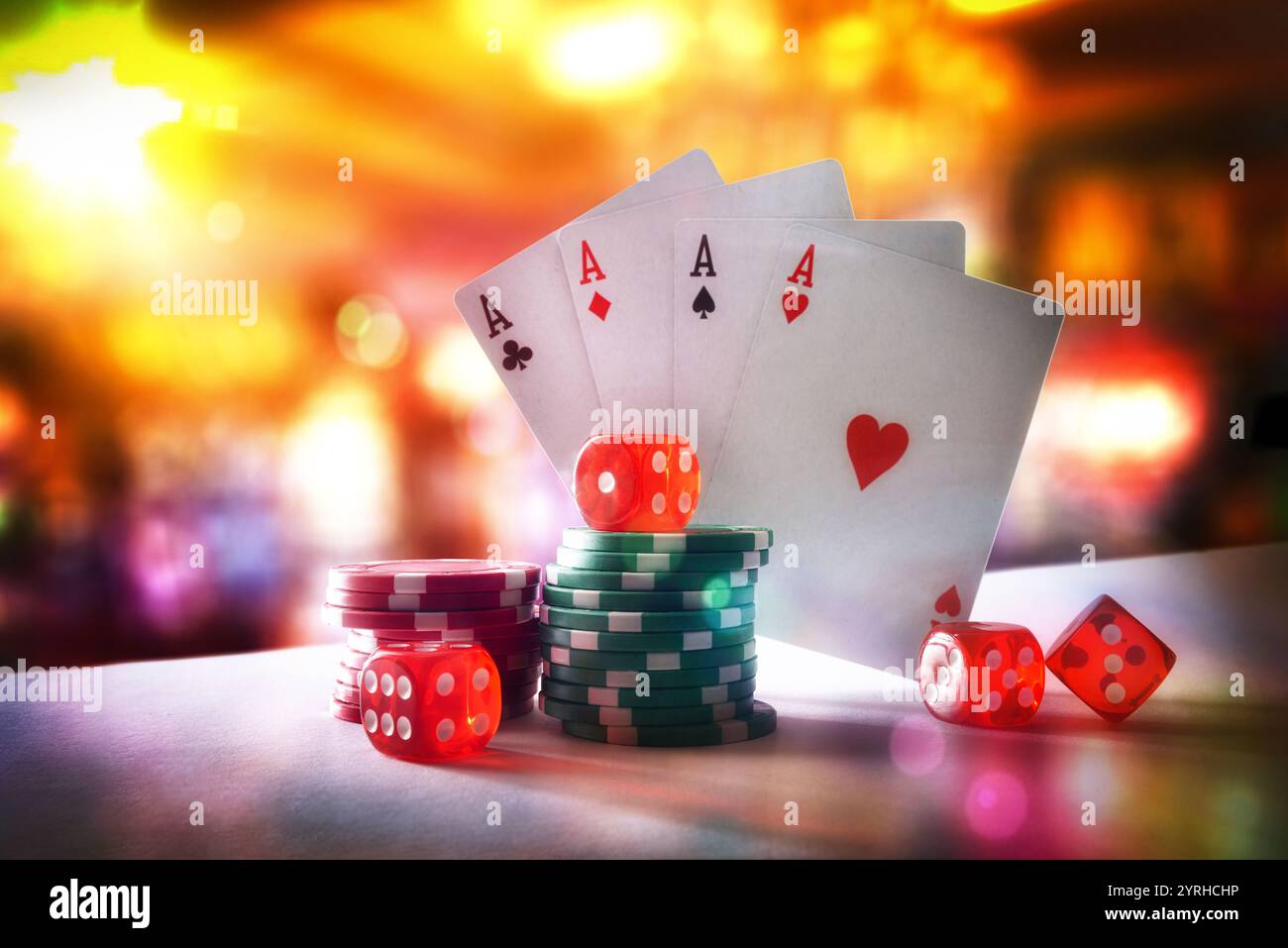 Giochi di carte e dadi con chip di scommessa su tavolo bianco e sfondo della sala giochi con luci. Vista frontale. Foto Stock