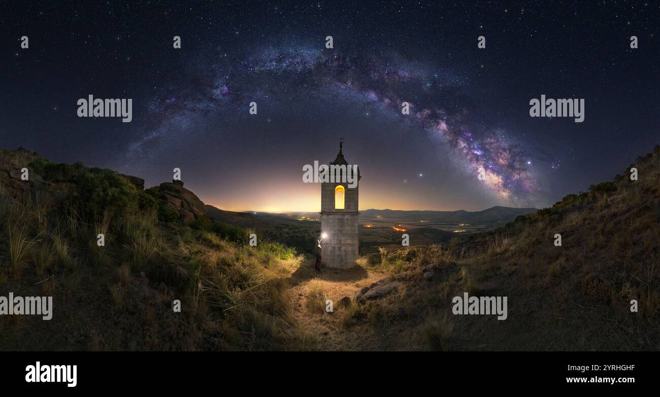 Una serena scena notturna con hermitage ad Avila illuminato sotto un cielo pieno di via Lattea, il paesaggio fonde bellezza naturale con architetto Foto Stock