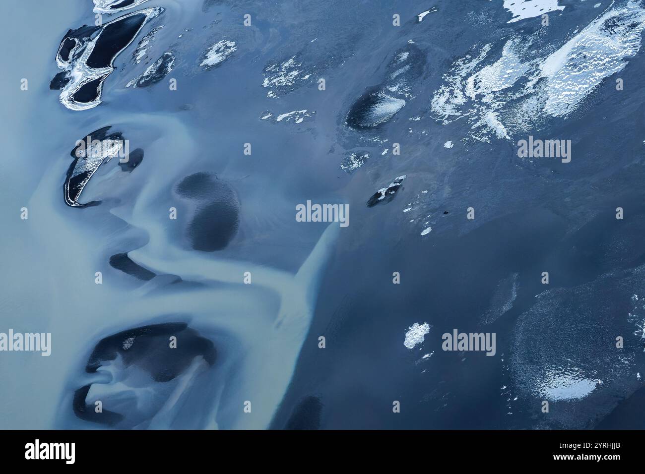Una splendida vista aerea della costa meridionale dell'Islanda, che mostra motivi astratti di formazioni ghiacciate e acqua scura, Un'accattivante miscela di texture e col Foto Stock