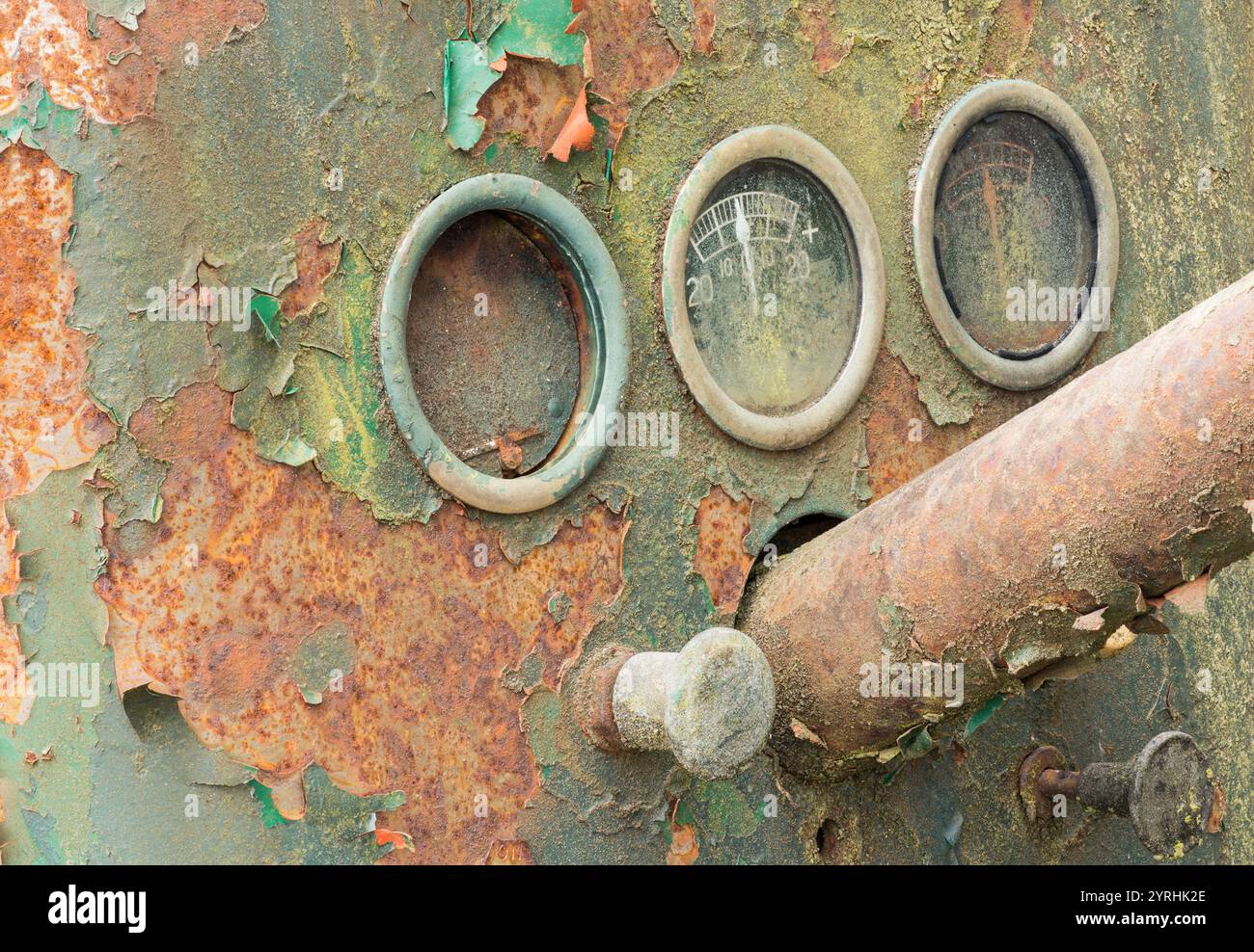 Primo piano di vecchi quadranti arrugginiti e vernice che sbucciava sui macchinari in un deposito di rifiuti, l'immagine cattura l'essenza del decadimento, dell'abbandono e del passare del tempo, evok Foto Stock