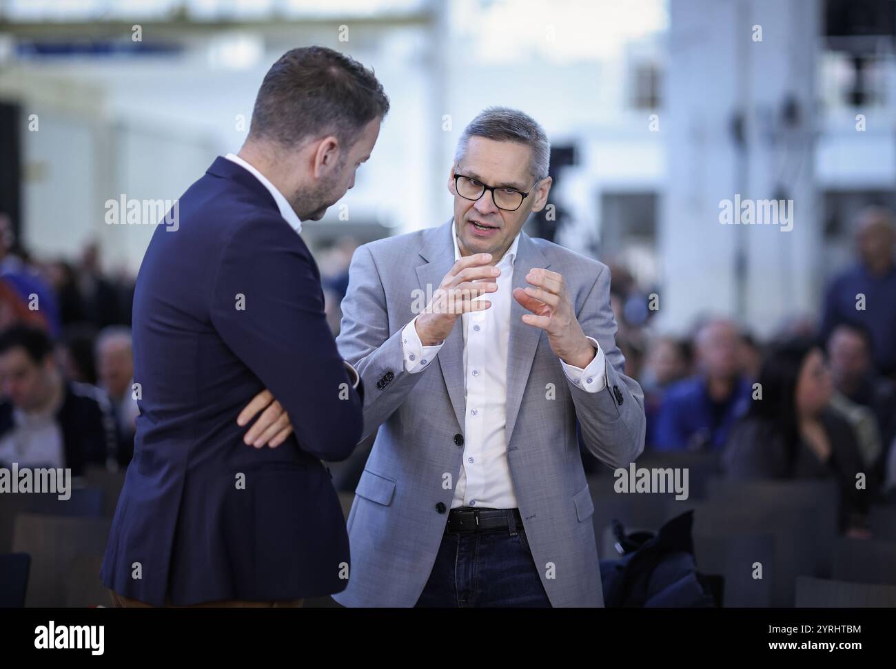 Wolfsburg, Germania. 4 dicembre 2024. Thorsten Gröger (r), capo negoziatore di IG Metall, parla con una persona non identificata durante una riunione di lavoro presso la sede centrale dell'azienda a Wolfsburg. I dipendenti della Volkswagen in tutta la Germania sono nel bel mezzo di un'escalation della disputa sul lavoro a causa della crisi che ha colpito l'industria automobilistica tedesca, con migliaia di posti di lavoro in gioco. Credito: Ronny Hartmann/AFP POOL/dpa/Alamy Live News Foto Stock