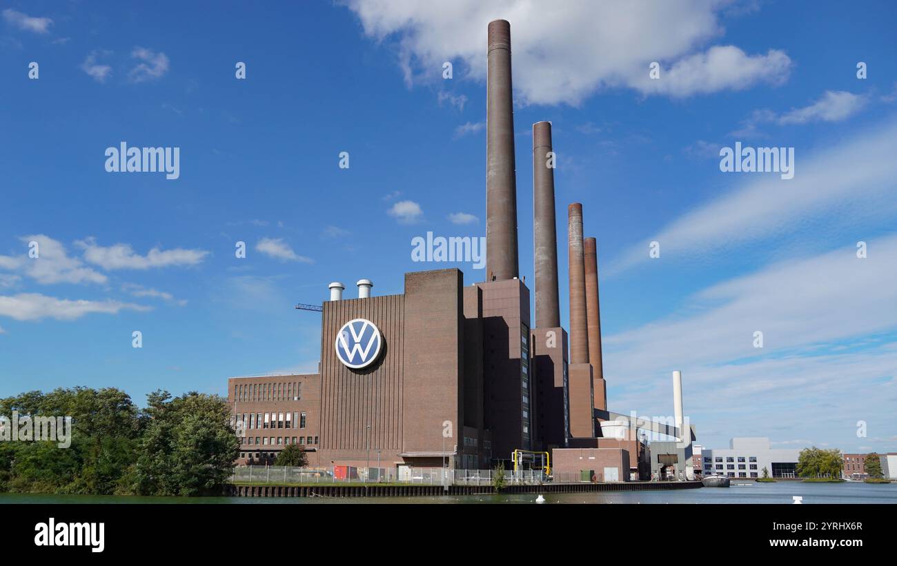 Vista dello stabilimento di produzione della sede centrale Volkswagen a Wolfsburg in una giornata di sole con molo e canale in primo piano e ampio tronco Volkswagen Foto Stock