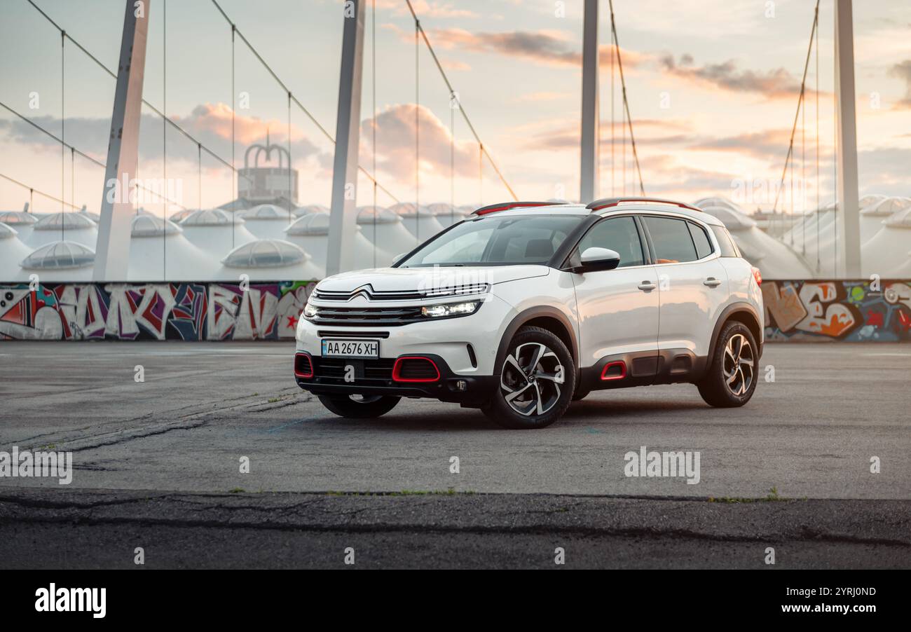 White Citroen C5 Aircross in un grande parcheggio al tramonto. Vista frontale di tre quarti del compatto incrocio francese di fronte al moderno stadio. Foto Stock