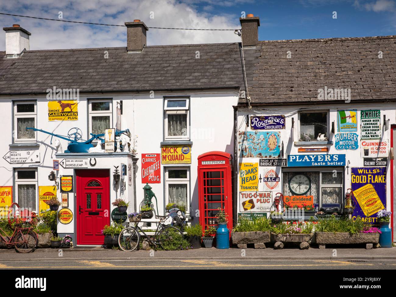 Irlanda, contea di Westmeath, Horseleap, Cappydonnell Little, casa privata decorata con cartelli e vecchia cassetta telefonica Foto Stock