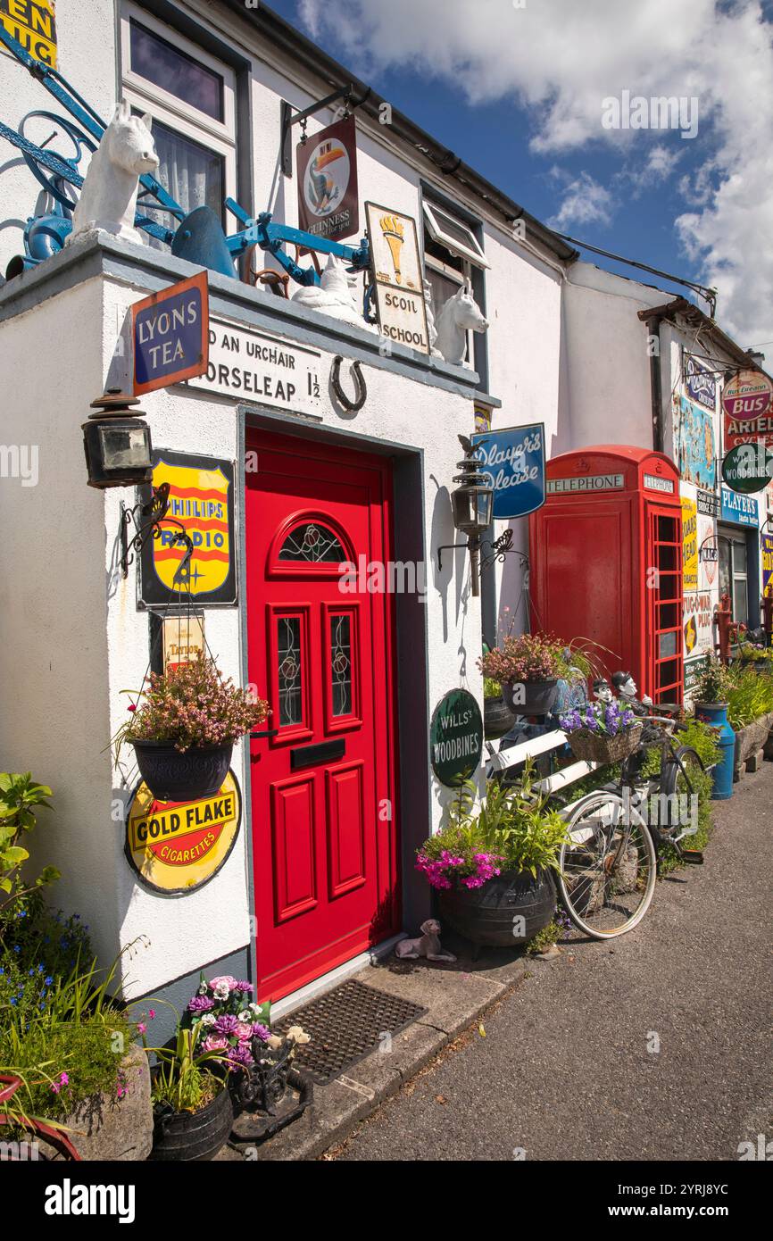 Irlanda, contea di Westmeath, Horseleap, Cappydonnell Little, casa privata decorata con cartelli e vecchia cassetta telefonica Foto Stock