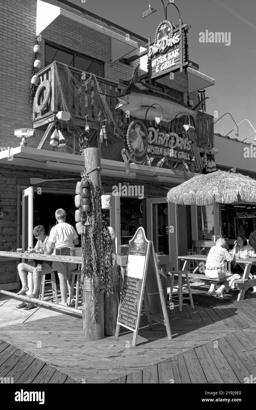 I turisti si godono un pasto in una caffetteria sul marciapiede lungo la vivace passerella di Myrtle Beach, South Carolina, Stati Uniti. Foto Stock