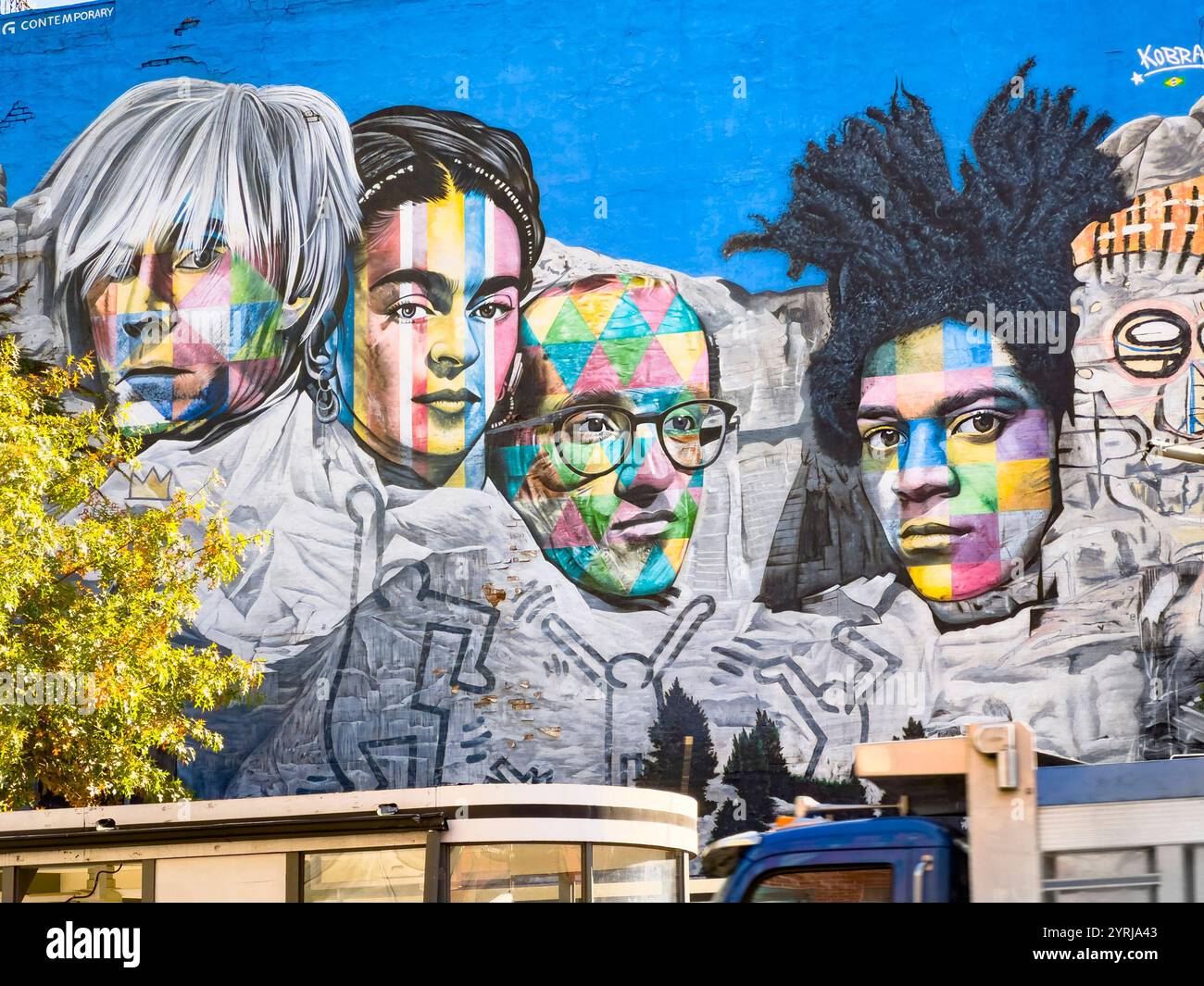 Vivace murale di Street art con ritratti colorati di artisti iconici su uno sfondo blu brillante in un ambiente urbano con andy warhol Frida Kahlo Foto Stock