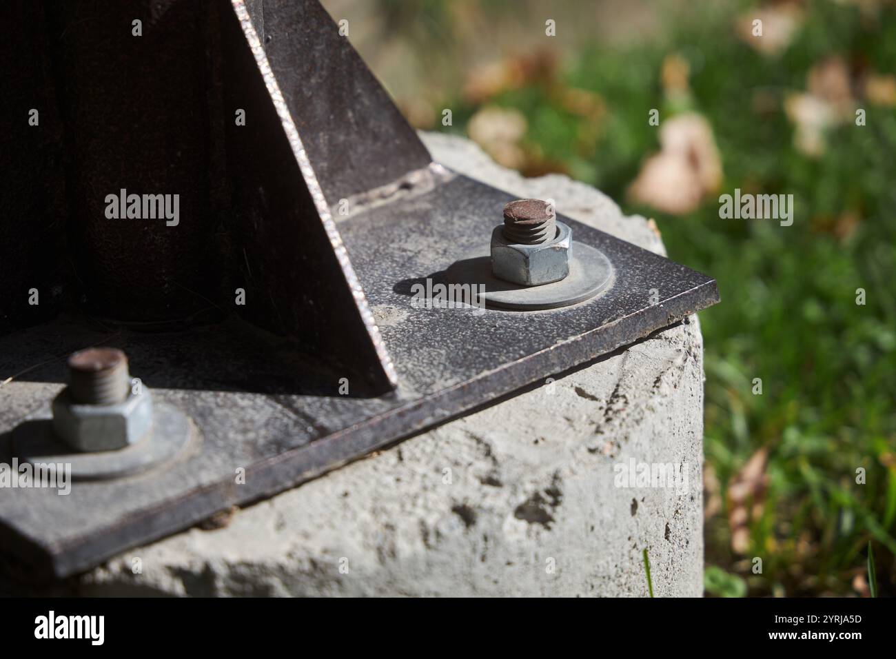 Bullone e dado, vite, guarnizione. Fissaggio di un palo metallico, strutture a una base in calcestruzzo. Dispositivi di fissaggio, bulloni, dadi, collegamento esterno Foto Stock