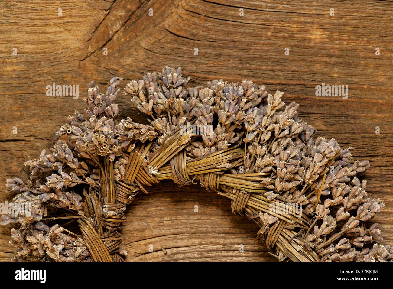 Corona fatta a mano in lavanda secca (Lavandula angustifolia) su fondo rustico in legno Foto Stock
