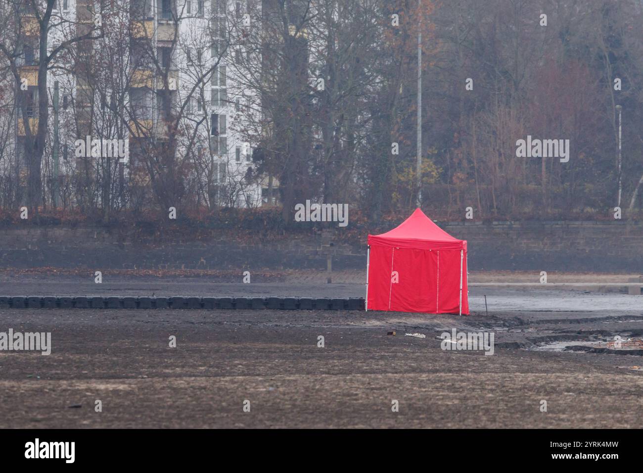 Norimberga, Germania. 4 dicembre 2024. Una tenda rossa di una società di smaltimento di ordigni esplosivi segna il luogo in cui una bomba aerea statunitense è stata trovata nello stagno drenato di Großer Dutzendteich. Secondo la città, la bomba inesplosa è stata scoperta la mattina del mattino nel Großer Dutzendteich dopo essere stata drenata. Inizialmente fu deciso di evacuare un'area entro un raggio di 350 metri intorno al sito. Circa 1.000 persone hanno dovuto lasciare le loro case da mezzogiorno. Crediti: Daniel Karmann/dpa/Alamy Live News Foto Stock