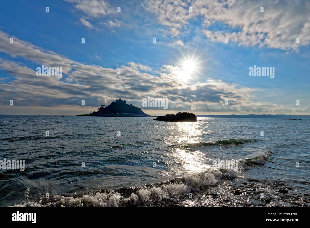 St Michaels Mount in semi-silhouette con forte sole autunnale contro un cielo blu con l'alta marea Marazion Cornovaglia Inghilterra Regno Unito Foto Stock