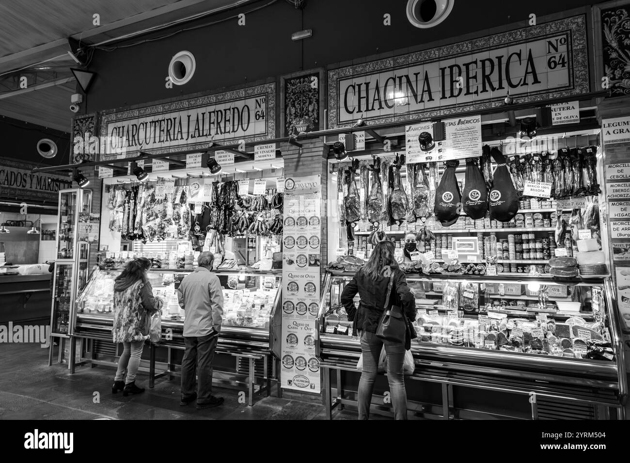 Siviglia, Spagna-24 febbraio 2022: Gente che fa shopping all'interno del Mercado de Triana, un mercato alimentare coperto nel quartiere Triana di Siviglia, Spagna. Foto Stock