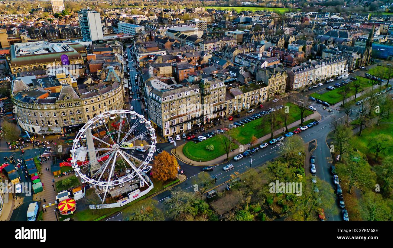Vista aerea del centro città, con ruota panoramica, grande hotel, numerosi edifici, auto parcheggiate e spazi verdi. L'immagine mostra una combinazione di archi Foto Stock