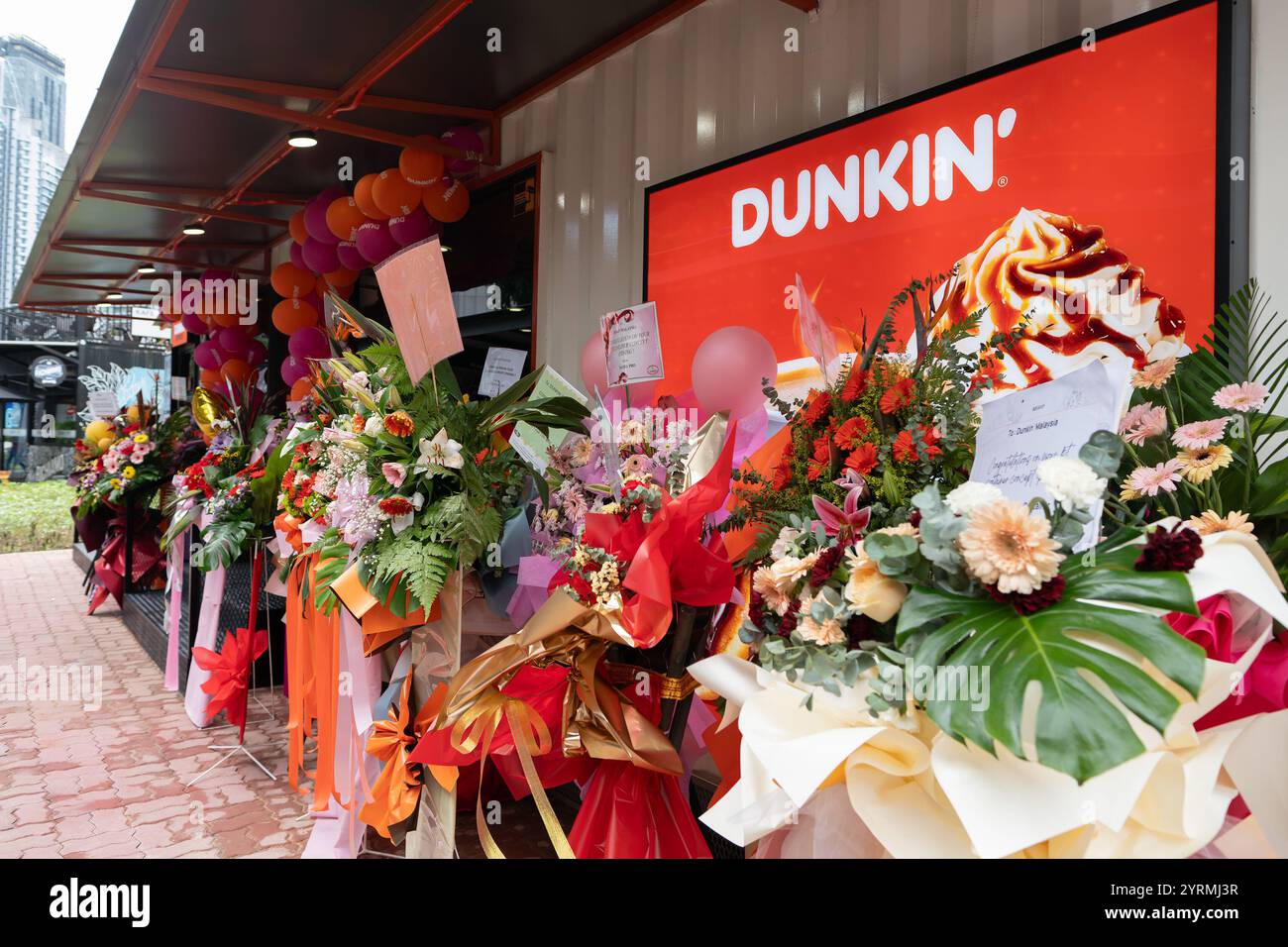 KUALA LUMPUR, MALESIA - 1 DICEMBRE 2023: L'outlet Container Concept Dunkin' Donuts presso la stazione MRT di Ampang Park, con tribune floreali Foto Stock