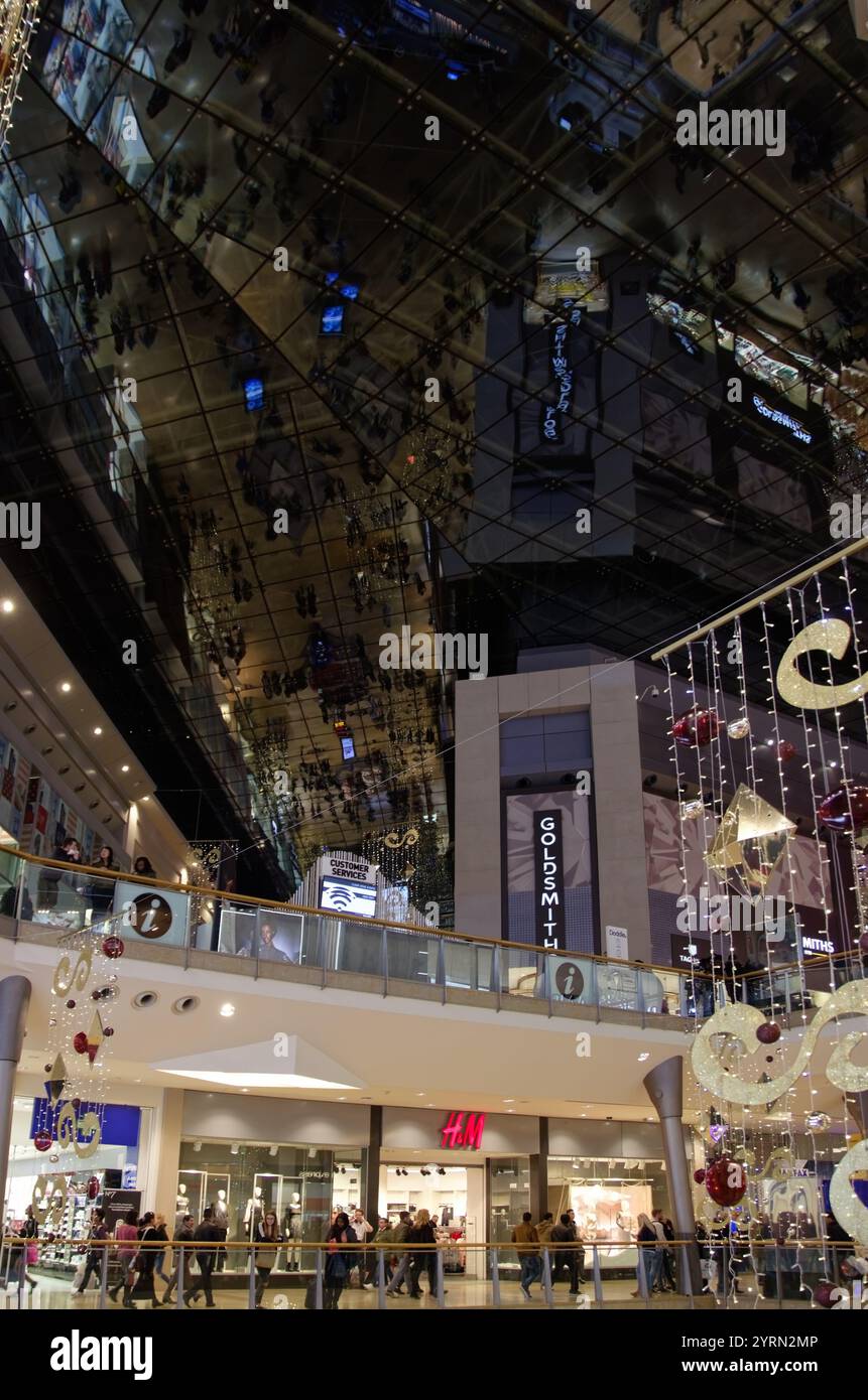 Luci natalizie e riflessi degli acquirenti nel Bull ring di Birmingham, Inghilterra Foto Stock