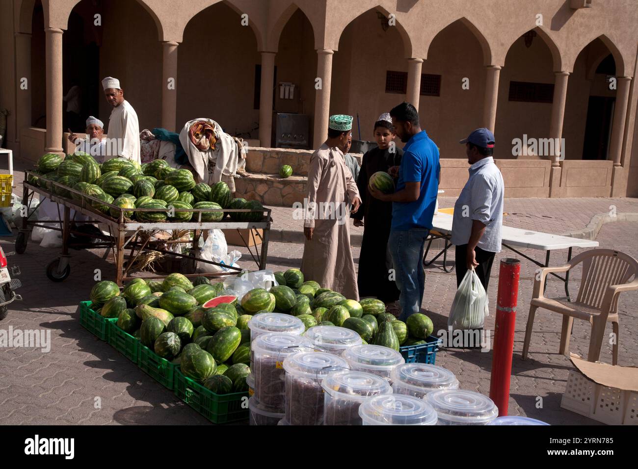 uomini dell'oman che fanno shopping nella stalla dell'anguria fuori nizwa suq nizwa oman medio oriente Foto Stock