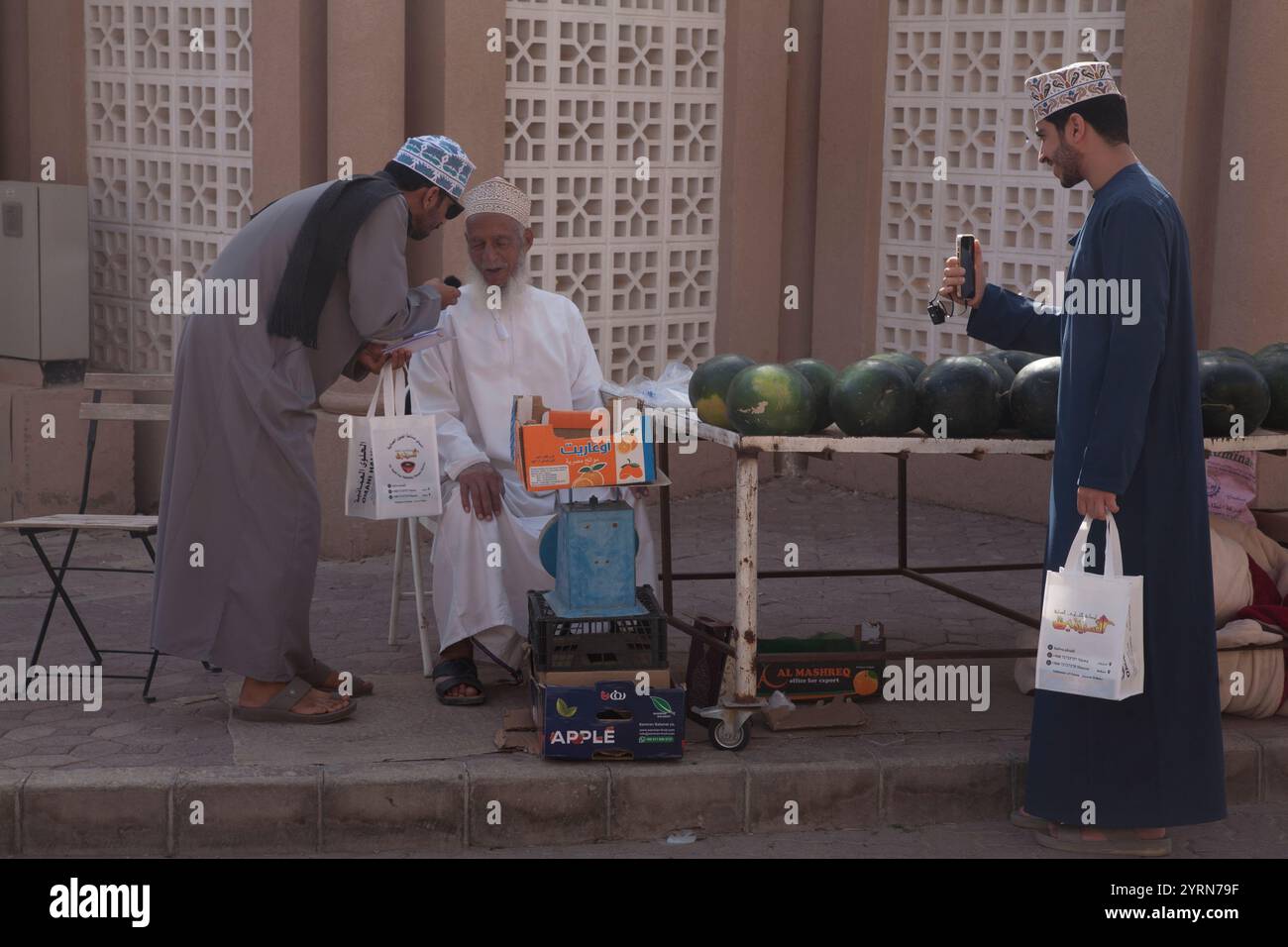 uomini dell'oman che fanno shopping nella stalla dell'anguria fuori nizwa suq nizwa oman medio oriente Foto Stock