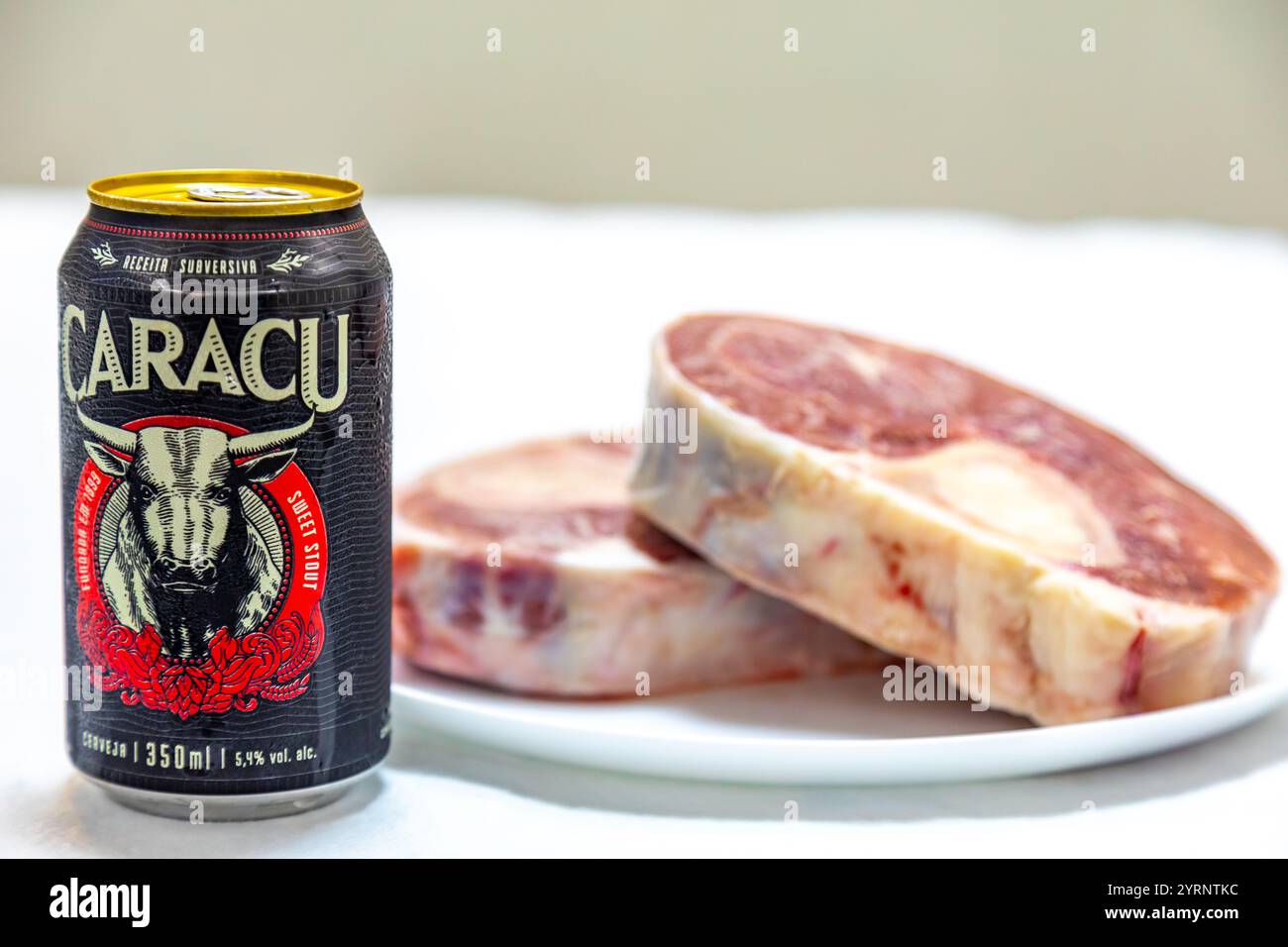 Birra scura Caracu con osso buco di manzo crudo. Foto Stock