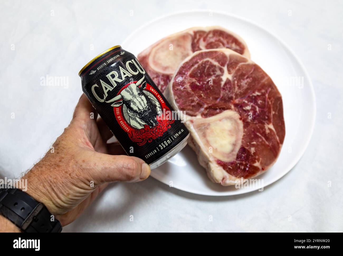 Birra scura Caracu con osso buco di manzo crudo. Foto Stock