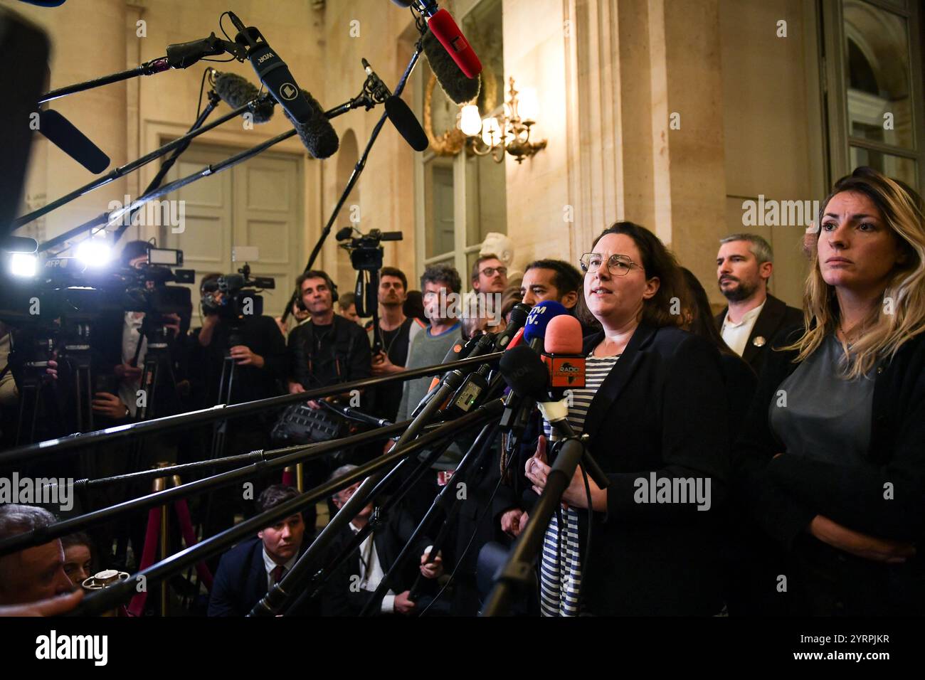 Cyrielle Chatelain, deputata francese e presidente del gruppo "Ecologiste et Social", parla alla stampa dopo una sessione di dibattito e votazione su due mozioni di censura all'Assemblea nazionale di Parigi, il 4 dicembre 2024. Le mozioni di censura portate dalla coalizione NFP di sinistra francese Nouveau Front Populaire (nuovo fronte Popolare) e dal partito RN di estrema destra del Rassemblement National (Rally Nazionale) in uno stallo sul bilancio di austerità del 2025, che vide il primo ministro francese forzare un disegno di legge per il finanziamento della sicurezza sociale senza voto (articolo 49.3) il 2 dicembre 2024. Foto di Firas Abdul Foto Stock