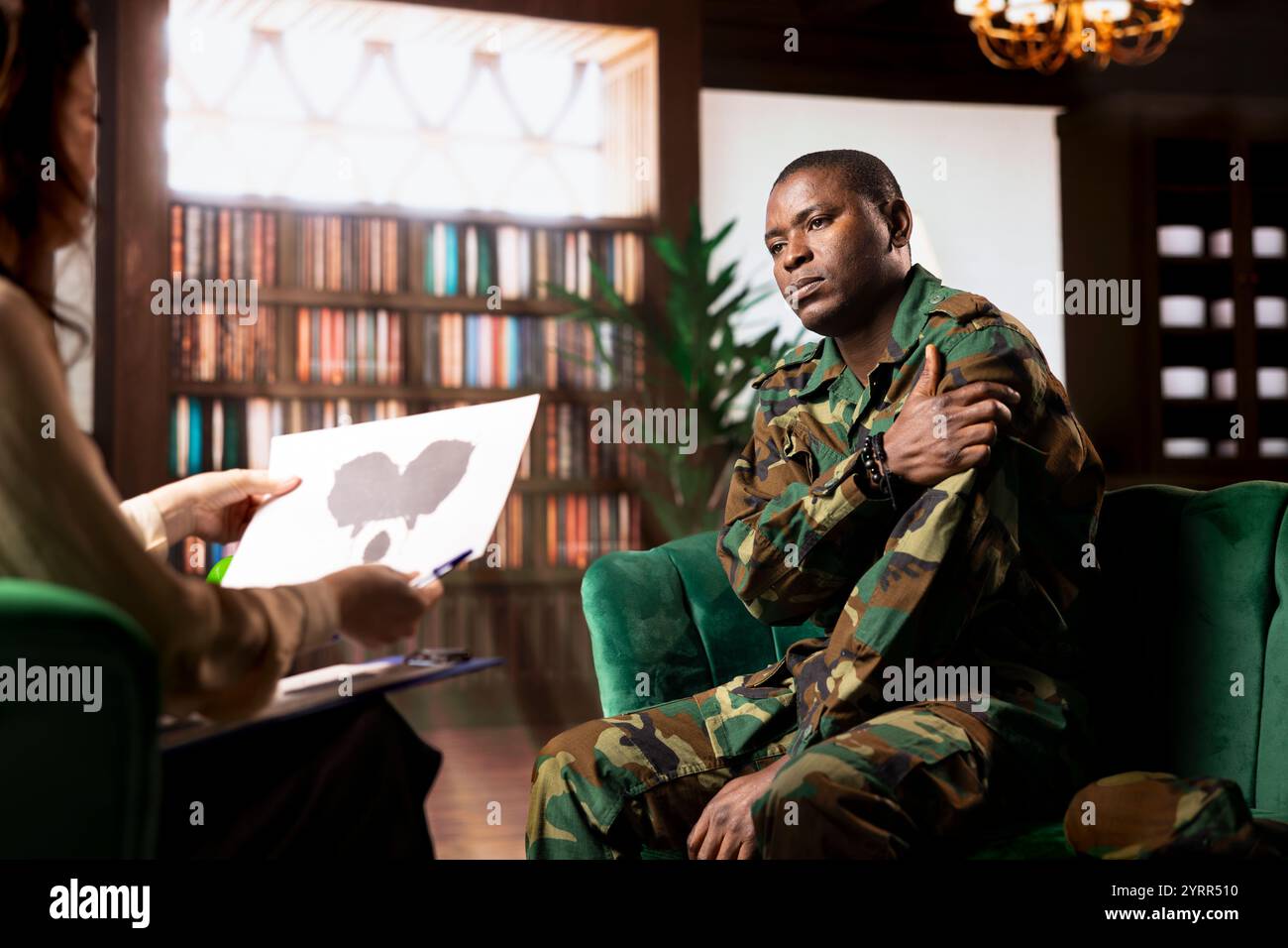 Il veterano militare studia il lotto di inchiostro di Rorschach in sessione di terapia con il consulente, affrontando i problemi di PTSD e recupero da trauma. Donna esperta mostra supporto psicologico per l'assistenza alla salute mentale. Foto Stock