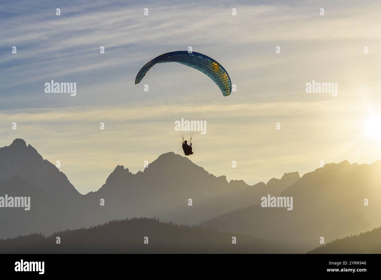 Parapendio sulla silhouette di montagna al tramonto con raggi di luce dorati, Schwangau, Ostallgaeu, Allgaeu, Svevia, Baviera, Germania, Europa Foto Stock