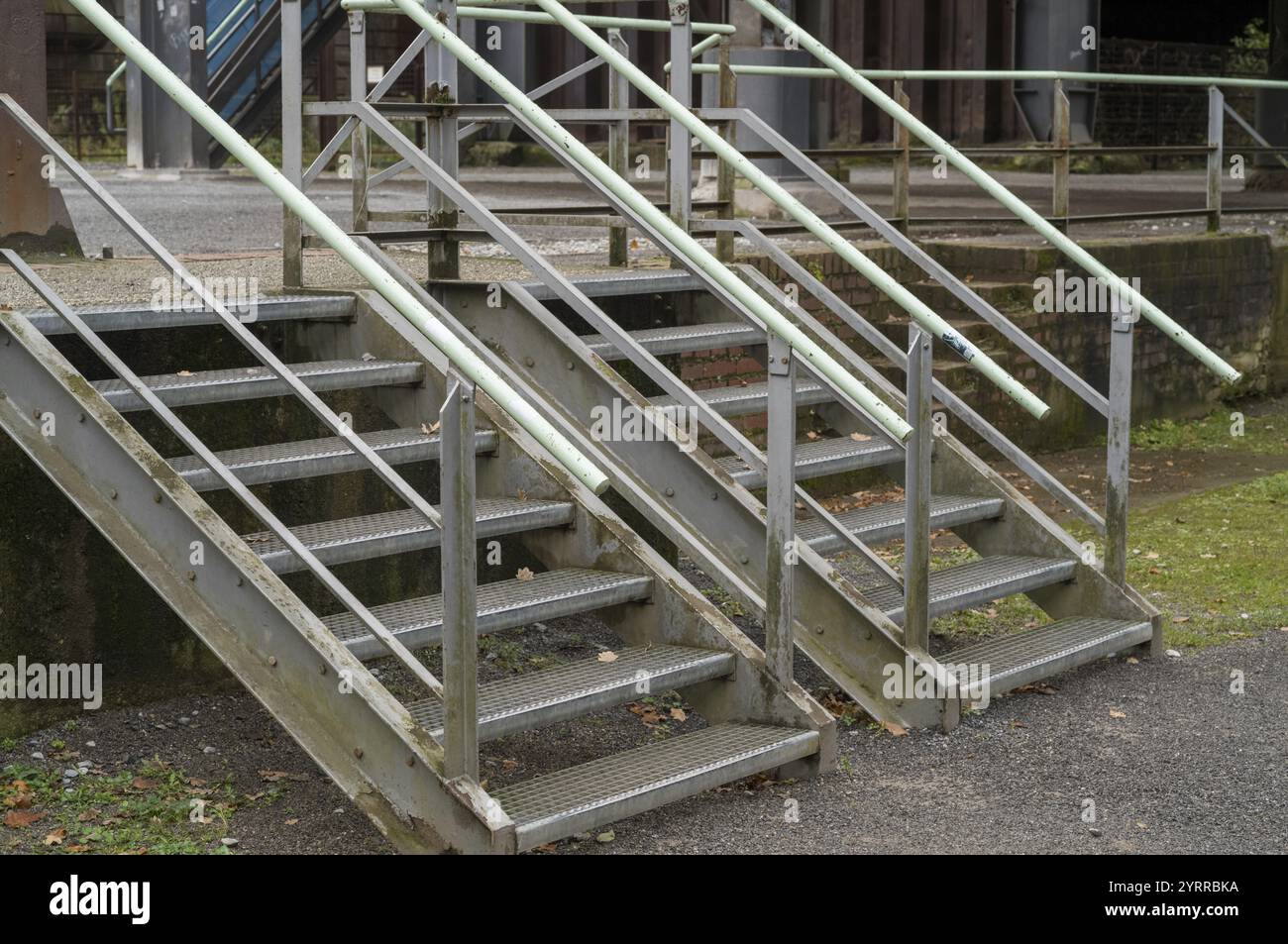 Due scalinate in metallo con corrimano consentono di accedere a un edificio industriale abbandonato Foto Stock