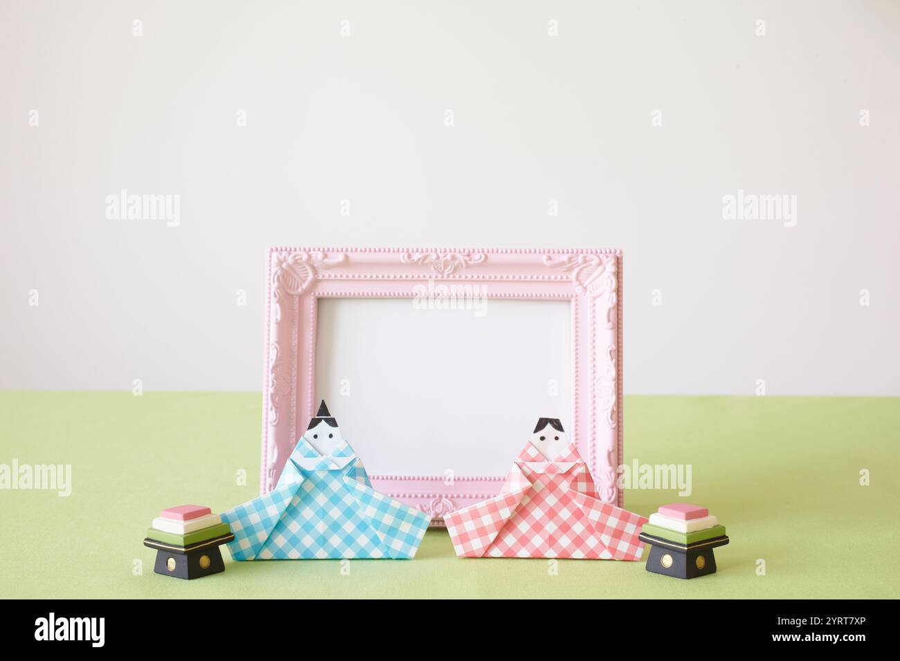 Bambole HiNA realizzate in origami e una cornice fotografica rosa Foto Stock