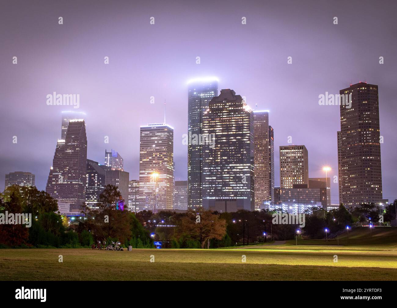 Edifici illuminati dello skyline del centro di Houston, Texas. Foto scattata in una serata nebbiosa e nuvolosa Foto Stock