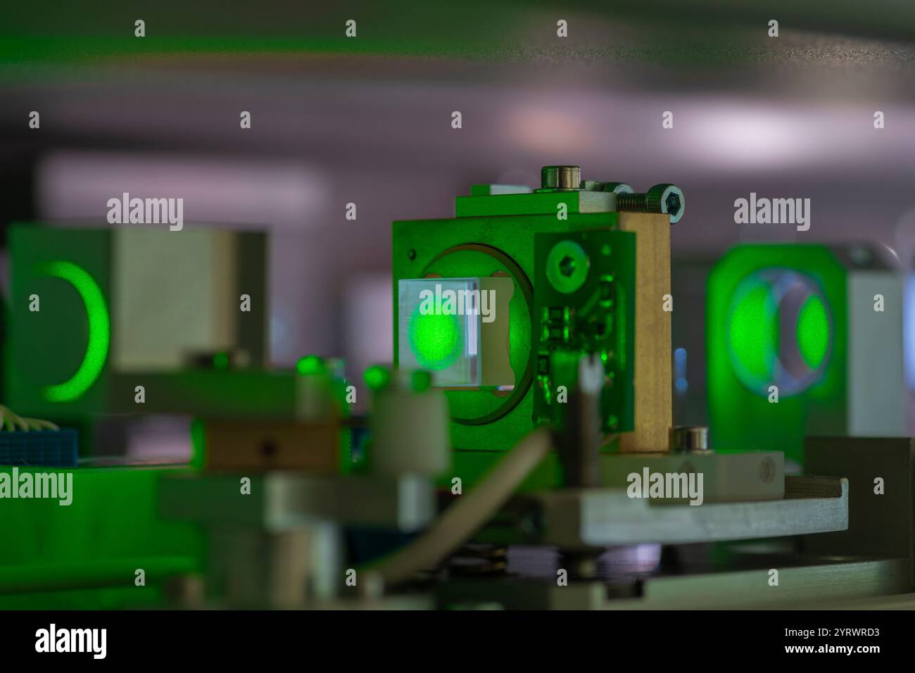 concentratevi sul punto laser verde su un cristallo ottico all'interno di un sistema laser scientifico Foto Stock