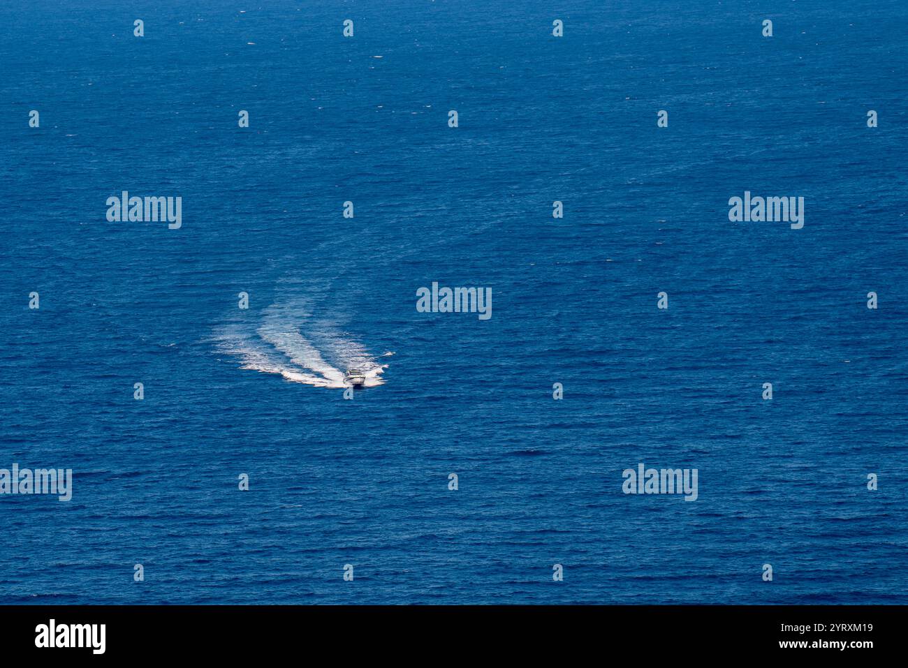 Un piccolo motoscafo da diporto naviga ad alta velocità su un mare blu calmo Foto Stock