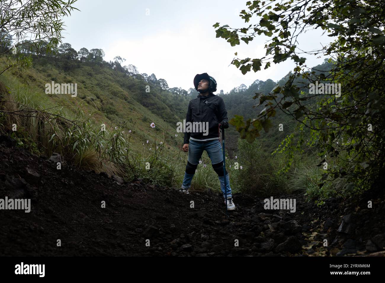 Un escursionista si erge con sicurezza su un sentiero accidentato a Volcan El Ajusco a città del Messico. Circondato da vegetazione lussureggiante e ripidi pendii, l'individuo gode di questo Foto Stock