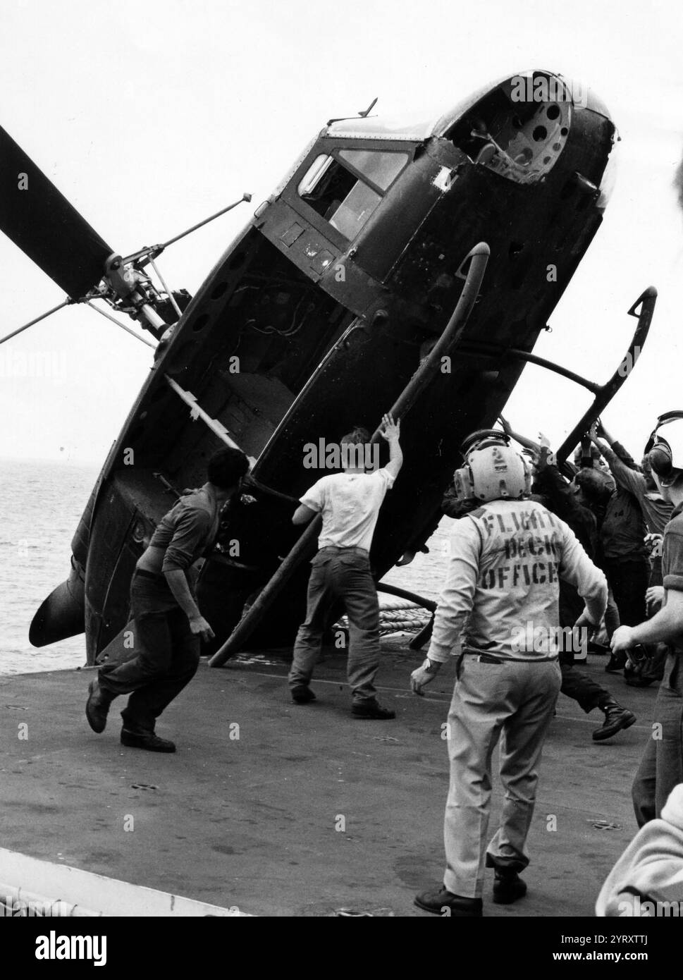 Un elicottero sudvietnamita viene spinto oltre il fianco della USS Okinawa durante l'operazione Frequent Wind, aprile 1975. L'elicottero, che trasportava due ufficiali vietnamiti, una donna e due bambini, doveva essere disposto a fare spazio per le estese operazioni elicotteri del corpo dei Marines che aiutavano ad evacuare la città di Saigon. Foto Stock