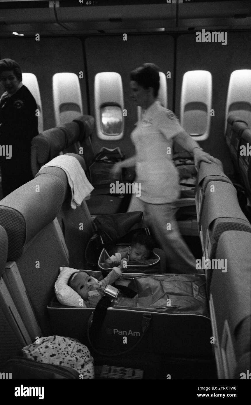 Infermiere e bambini vietnamiti rifugiati su un volo Operation Babylift al suo arrivo all'Aeroporto Internazionale di San Francisco 1975 Foto Stock