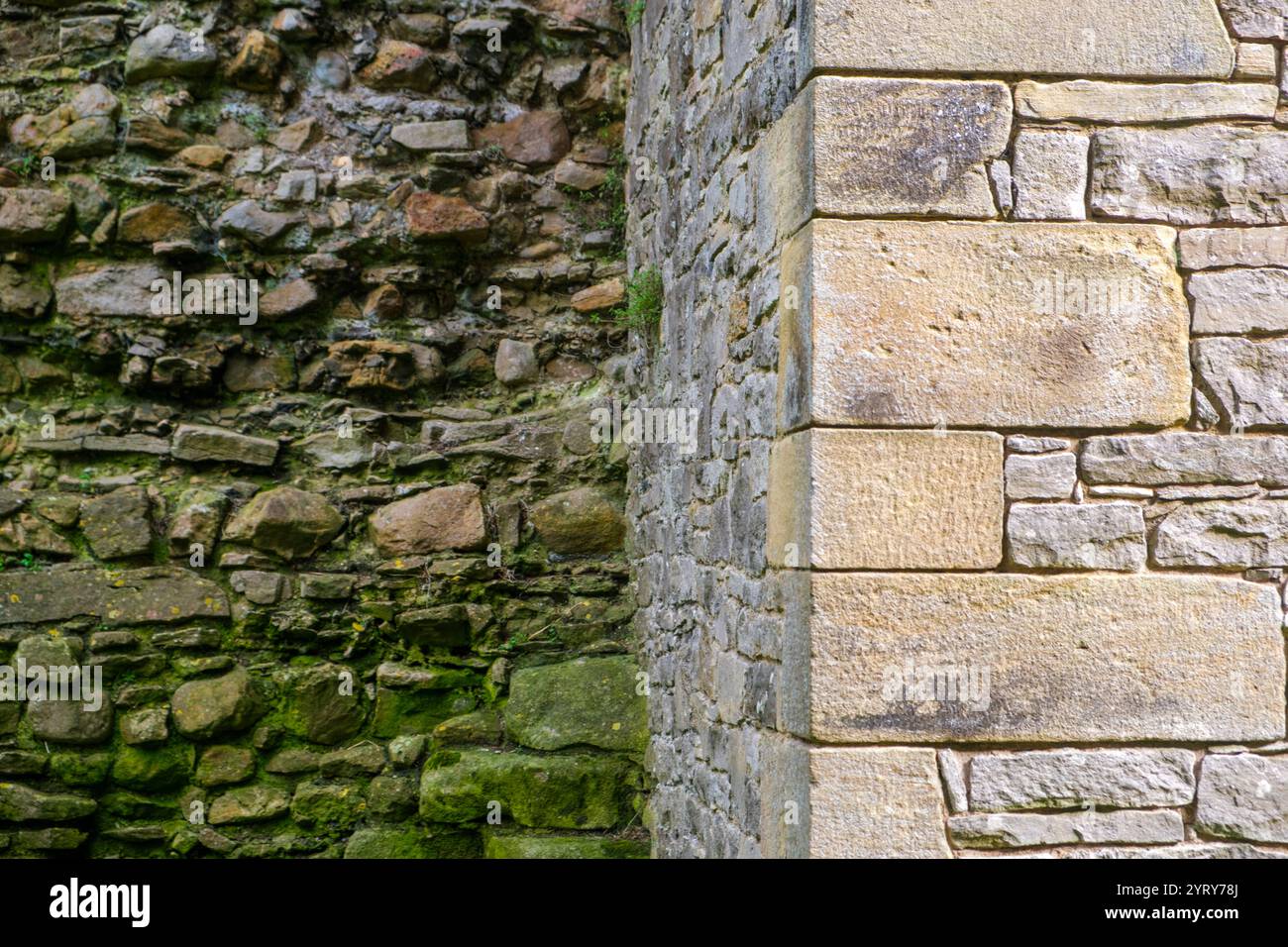Pareti in pietra smaltata restaurata a contrasto e vecchie pareti in pietra di macerie Foto Stock